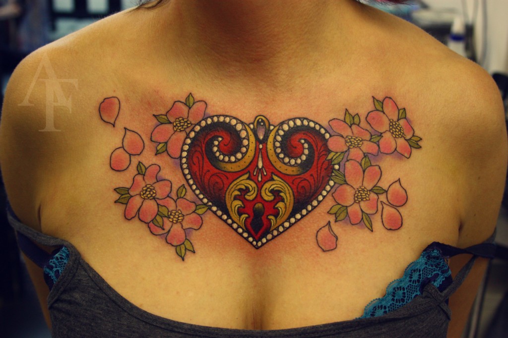 heart chest tattoo with flowers on womans chest with cleavage